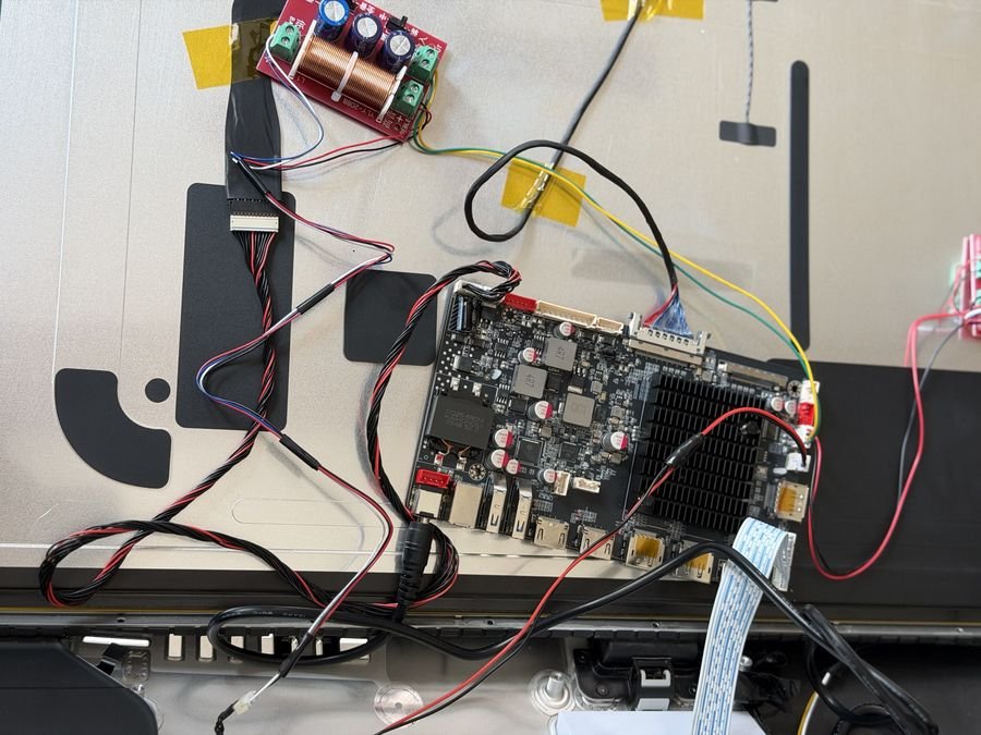 Close-up of the R1820 board wired to the eDP cable, backlight cable, crossover board and controller ribbon during bench testing