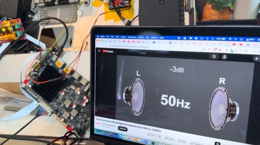Laptop playing a left and right channel frequency sweep test at 50 Hz while the R1820 board sits wired up on the bench beside it